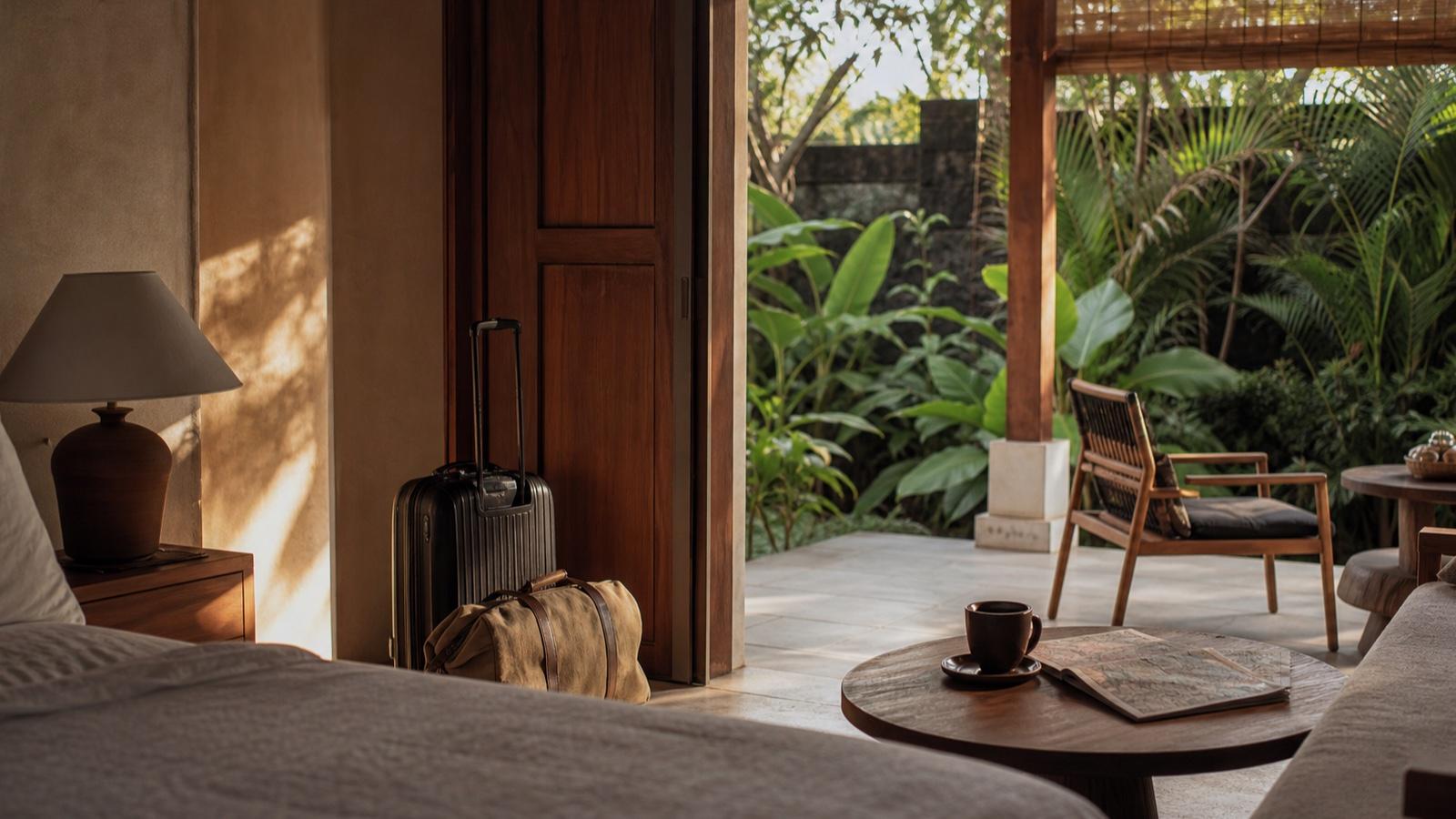 Packed luggage beside a quiet tropical hotel veranda in morning light